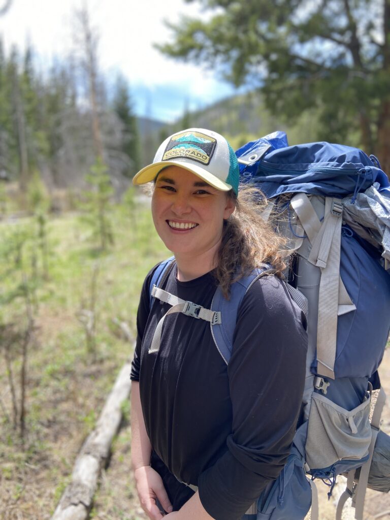 Doctor Brianna Anthony on a hiking trail with a treking backpack in the Rockies